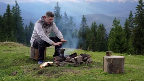 A man near a fire in the mountains Stock Footage 142203133