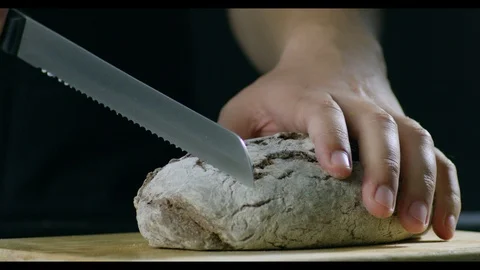 Man With A Neat Hands Cutting Bread On A Wooden Chopping Board Stock Footage 96197546
