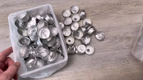 A man neatly places empty candlelight caps into a container Stock Footage 321481816