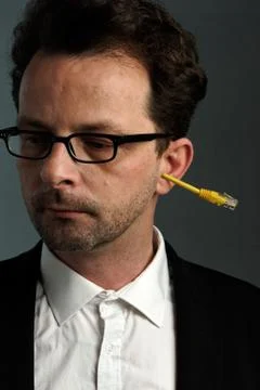 A man with a network connector in his ear Stock Photos
