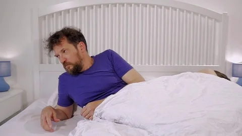 Man at night in bed with girlfriend depressed and angry Stock Footage 75958895