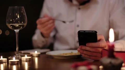 Man with nomophobia is using smartphone during a romantic dinner Stock-Footage 149424604