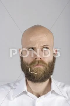 A man with a noodle in his beard Stock Photos