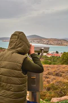 A man on an observation deck looks through a telescope. Stock Photos