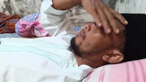 A man observes fast (Ramadan), lying down indoors. Stock Footage 321931322