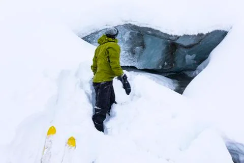 A Man Observes A Stream Emanating From Beneath Fels Glacier In The Alaska Range Stock Photos