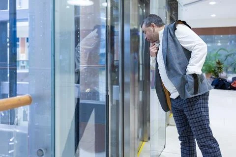 Man Observing Glass Elevator Stock-Fotos