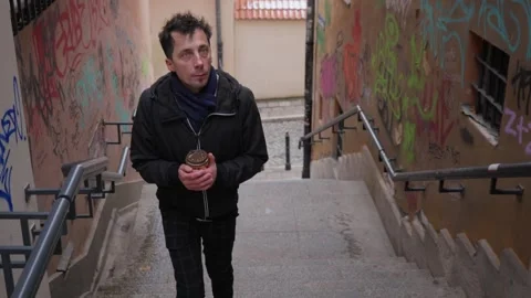 Man observing graffiti tags and vandalism on historic city walls Stock Footage 311192995