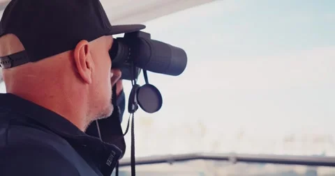 Man Observing Landscape with Binoculars on Boat Stock Footage 323793333