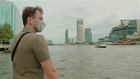 Man observing scenic urban riverfront, city exploration Видео 257496867