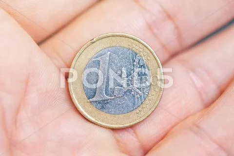 Man offering one euro coin on hand palm Stock Photos