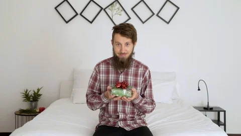 Man offers a present to the camera in an authentic room. Video stock 102655080