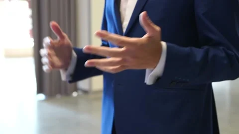 Man in office building in blue jacket explains shows with hand gestures on stage Stock Footage 134813334