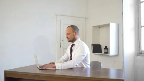 Man in office with computer sitting at desk, freelancer working from home office Stock Footage 143939817