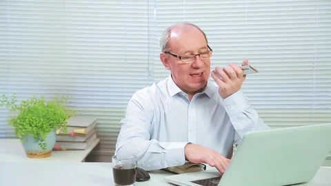 The man in the office at the computer speaks on the phone and works Stock Footage 146206604