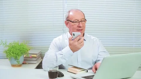 The man in the office at the computer speaks on the phone and works Stock Footage 147399210