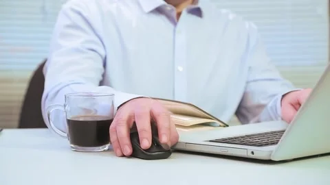 A man in the office at the computer works with projects next to coffee Stock Footage 146804735