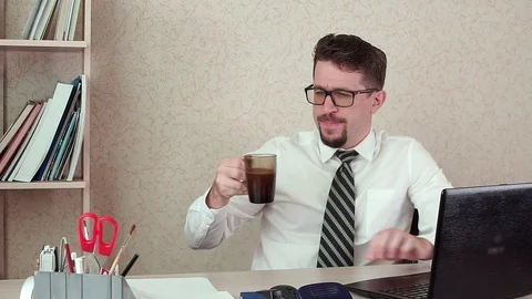 Man office Manager with a beard and glasses, happy drinking coffee. Video stock 100397275