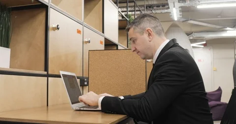 Man office manager is working on laptop sitting in modern coworking center. Stock Footage 121844051