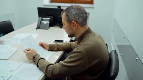 A man in the office is studying the wine documents. Stock Footage 136310593