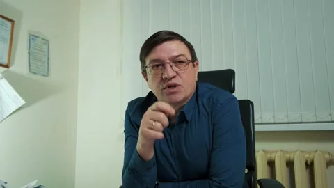 A man in the office is talking to a man outside of the frame Stock Footage 149075866