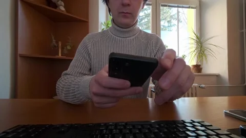 A man in an office is using the phone at his desk. A close-up of the phone Видео 333286375