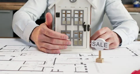 Man office worker gently closes small door of house model Stock Footage 314730891