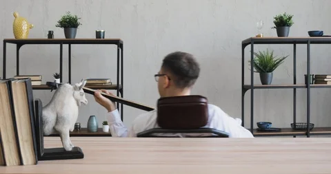 Man office worker playing a guitar and rotating on chair enjoying his time. Stock Footage 120834508