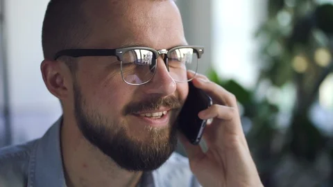Man office worker talking on the smartphone with smile in office closeup Stock Footage 126702023