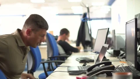 A man in the office at the workplace talking on a landline phone and working Stock Footage 80391983