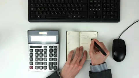 A man in the office writes tasks for the day in the diary on a white table 스톡 동영상 101839746