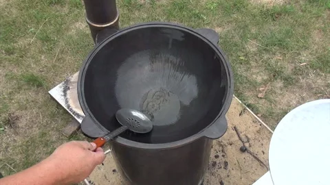 A man oils a hot grill. Brazier on an open fire. Shot from above. Stock Footage 279803202