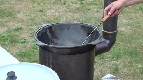 A man oils a hot grill. Brazier on an open fire. Stock Footage 279803302