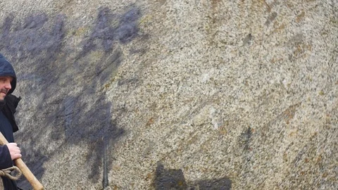 Man in old clothes with pickaxe moves and stop for a moment Stock Footage 104561820