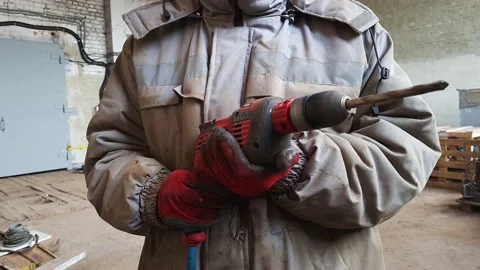 Man in old dirty uniform working with electric drill in a workshop. Stock Footage 151257255