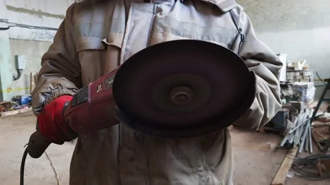 Man in old dirty uniform working with electric grinder tool in a workshop. Stock Footage 151257466