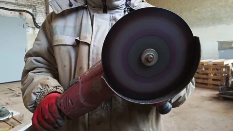 Man in old dirty uniform working with electric grinder tool in a workshop. Stock Footage 152036254