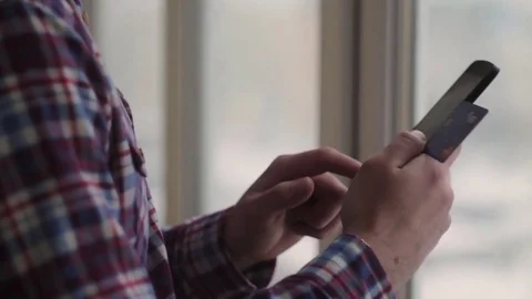 Man online banking using smartphone shopping online with credit card at home Stock Footage 70899169