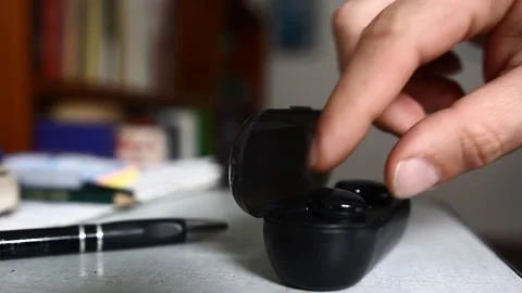 A man open and take a pair of wireless headphones from its charging case Vídeos de archivo 218641678
