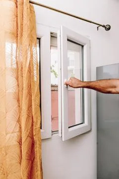 Man Open Window for Fresh Air And Cool Home In Summer Heat, house burping tre Stock Photos