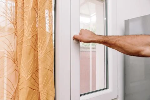 Man Open Window for Fresh Air And Cool Home In Summer Heat, house burping tre Stock Photos