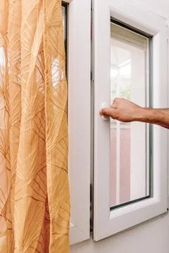 Man Open Window for Fresh Air And Cool Home In Summer Heat, house burping tre Stock Photos