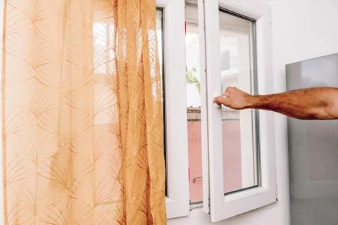 Man Open Window for Fresh Air And Cool Home In Summer Heat, house burping tre Stock Photos