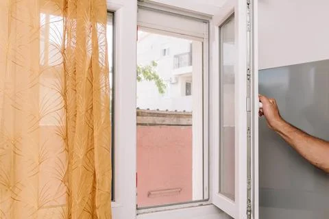Man Open Window for Fresh Air And Cool Home In Summer Heat, house burping tre Stock Photos