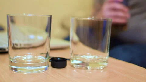 The man opened the bottle with an alcoholic drink. Stockbeeldmateriaal 104841902