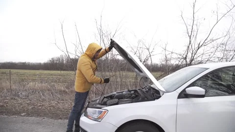 A man opened the hood of a car, trying to figure out what the problem was. Stock Footage 264094820