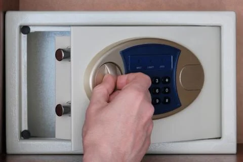 The man opened the safe hidden in the office in the closet to put the money.  Stock Photos