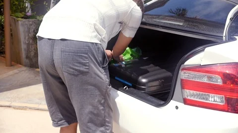 The man opened the trunk of the car and stacked things outside, bringing order Stock Footage 87448617