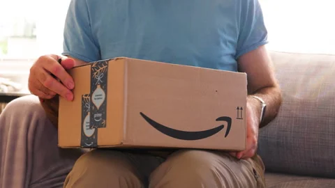 Man Opening Amazon Parcel on Couch Stock Footage 308449088