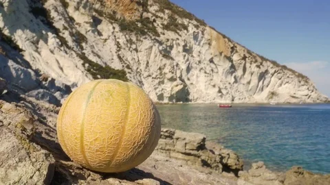 Man opening and eating a melon at the beach on desert island Stock Footage 80187175